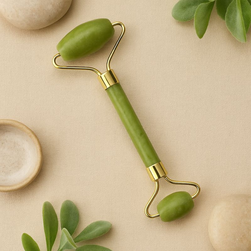 Accessoire beauté rouleau visage en jade vert posé dans un décor bien-être