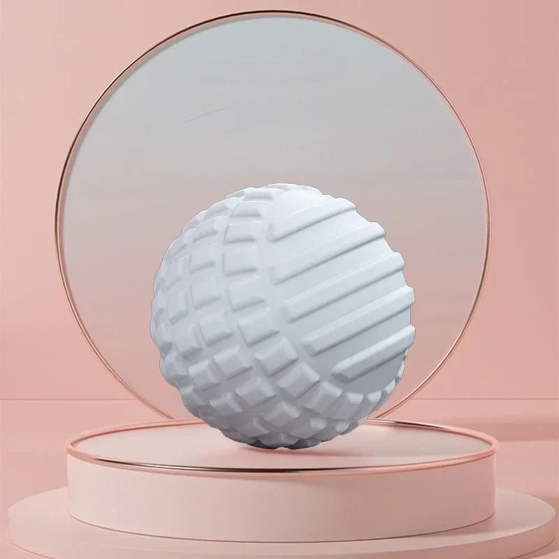 Boule de massage blanche avec relief sur socle rose clair