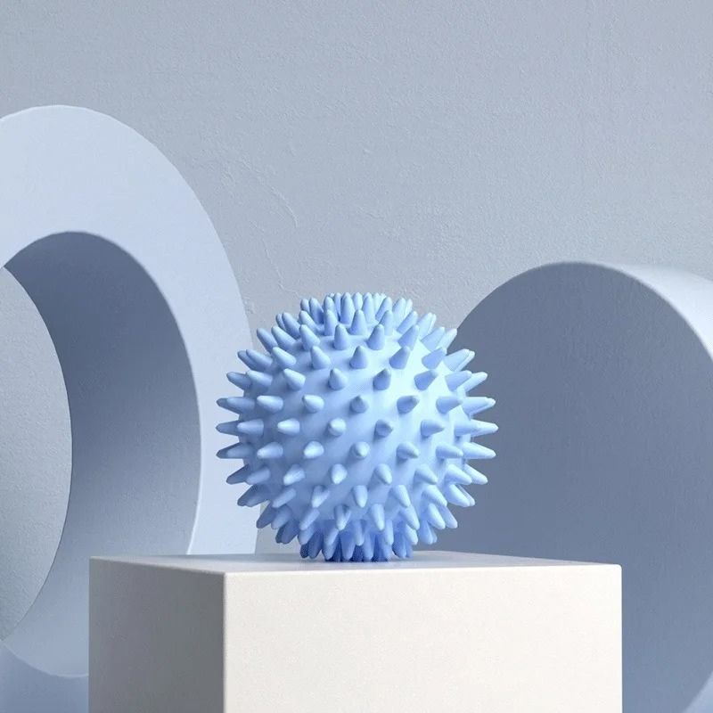 Balle de massage picots bleue sur fond bleu pastel, ambiance douce et relaxante