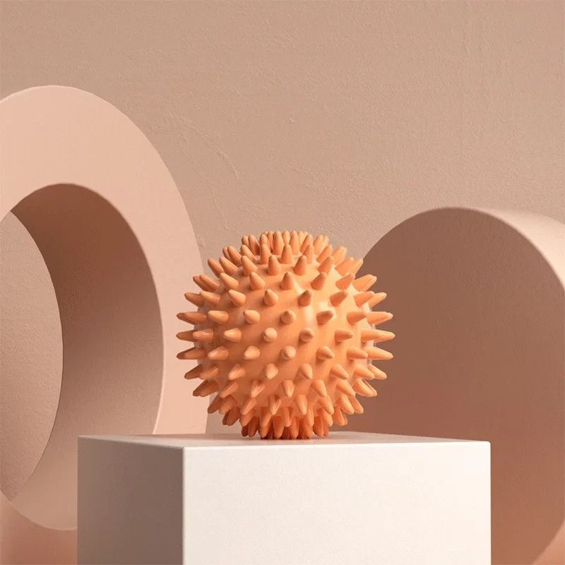 Balle de massage picots orange en relief sur fond beige, mise en valeur artistique