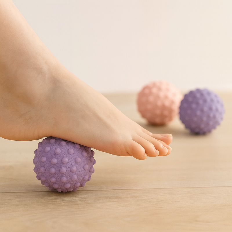 Utilisation d’une balle de massage pieds violette sous un pied pour soulager les tensions plantaires