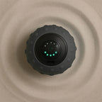 Balle de massage vibrante noire sur une surface texturée beige