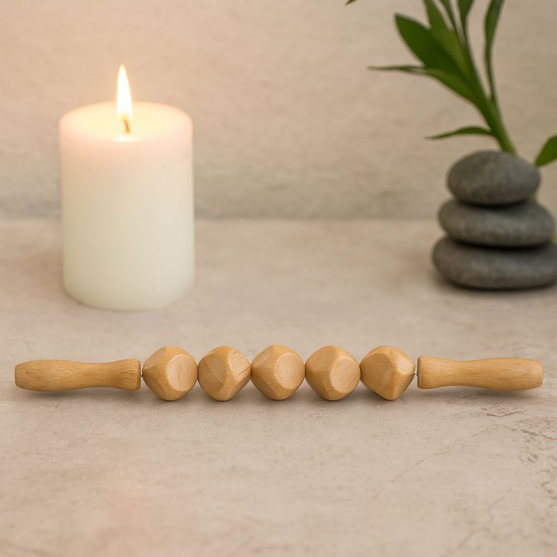 Bâton de massage en bois dans un cadre zen avec bougie, outil de relaxation et massage manuel