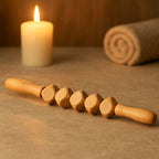 Bâton de massage en bois posé dans une ambiance tamisée de spa, idéal pour soulager les tensions musculaires