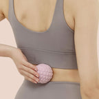 Utilisation d’une boule de massage rose sur le bas du dos