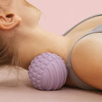 Utilisation d’une boule de massage violette sous la nuque en position allongée