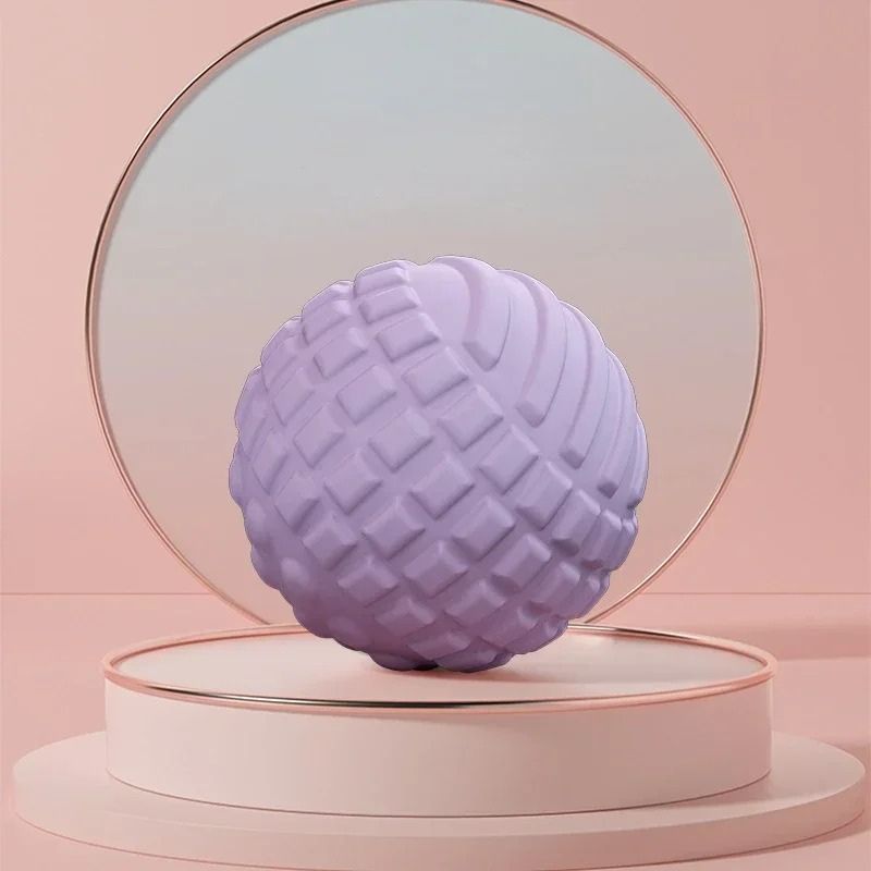 Boule de massage violette sur fond rose dans un décor minimaliste