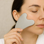 Femme utilisant un Gua Sha en acier inoxydable sur la joue