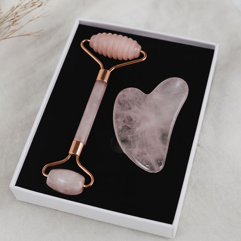 Kit Gua Sha avec rouleau texturé et pierre en quartz rose sur support naturel