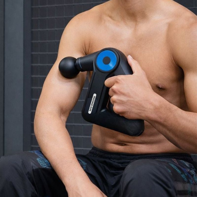 Pistolet de massage compact appliqué sur l’épaule et le bras pour détendre les muscles après l’effort.