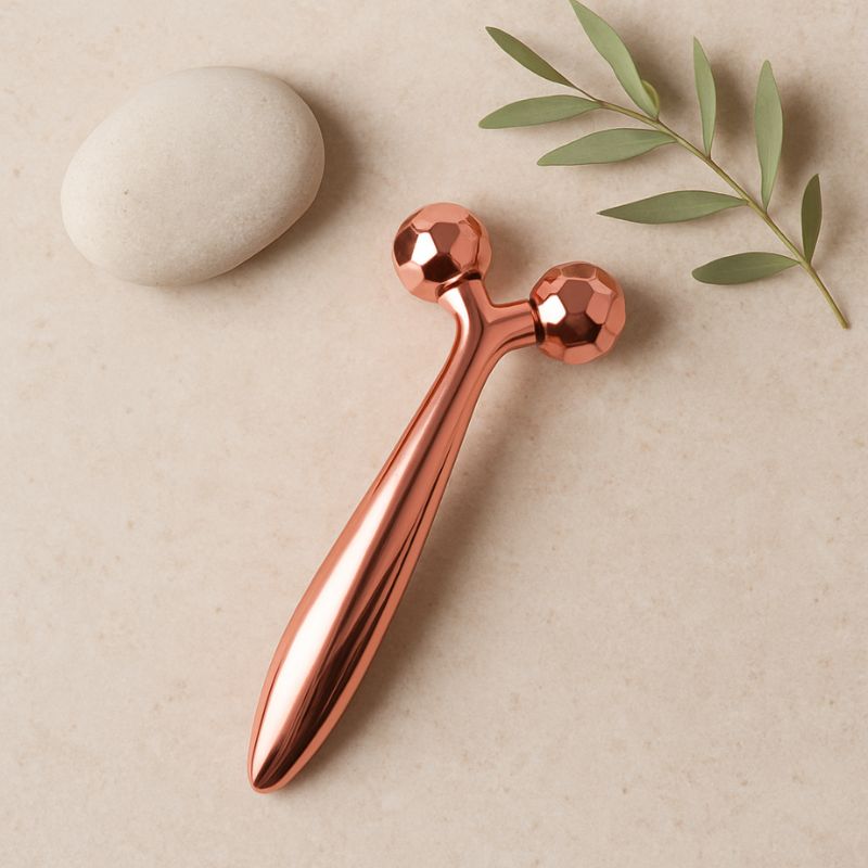 Roll on visage rose gold avec galet et feuille verte en mise en scène naturelle