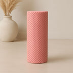 Rouleau massage jambe rose présenté dans un environnement minimaliste et zen