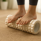 Rouleau de massage musculaire blanc utilisé sur les pieds