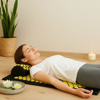 Femme détendue allongée sur un tapis d'acupression à fleurs jaunes dans un décor zen