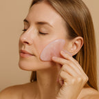 Femme utilisant une pierre Gua Sha en quartz rose pour lisser les traits du visage